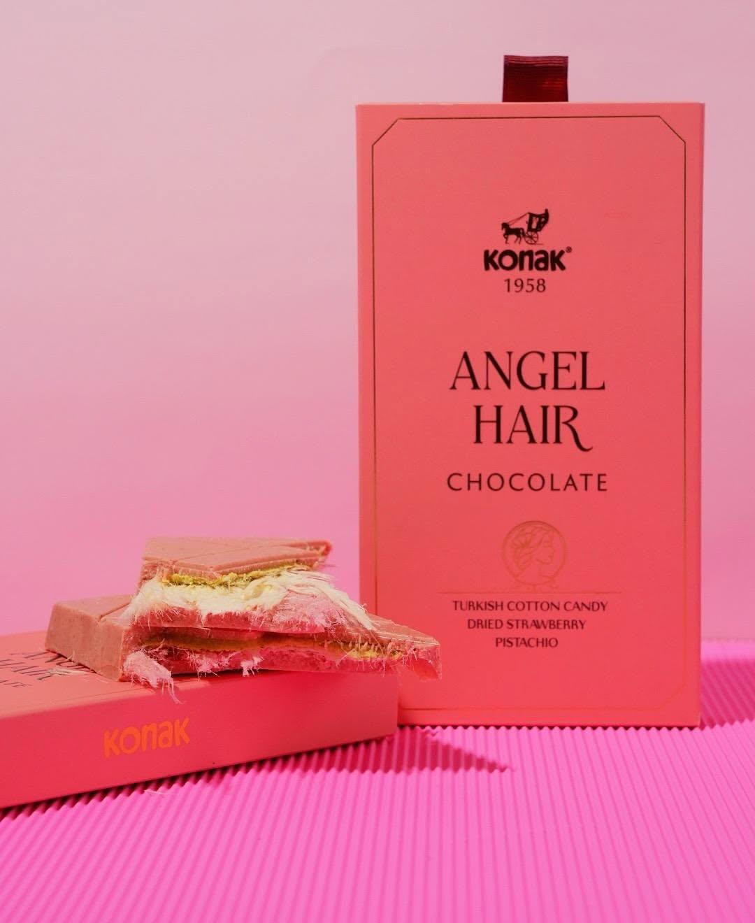 Elegant presentation of the Angel Hair chocolate bar with its luxurious pink packaging, placed on a table