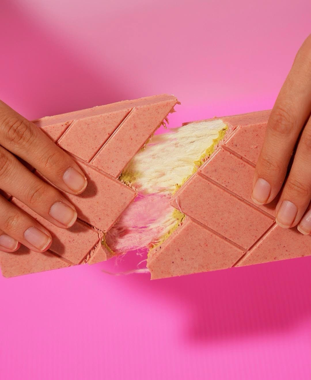 Cracking the Angel Hair chocolate bar to expose the fluffy cotton candy filling inside.