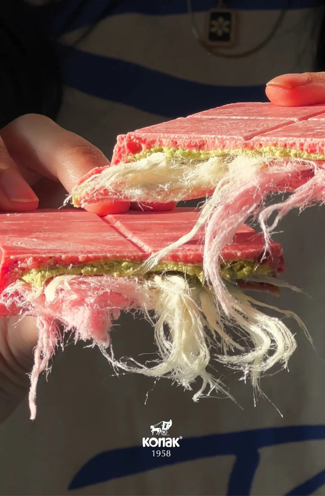 Close-up of the luxurious Angel Hair Chocolate Bar by Konak, featuring a layer of Turkish cotton candy (pişmaniye), creamy pistachio filling, and ruby chocolate.