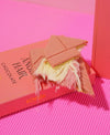A gourmet pistachio cream chocolate bar by Konak, showcasing a soft, silky white chocolate base and delicate pişmaniye (cotton candy) texture.
