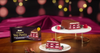 Slice of layered dessert on a plate with a box of Ulker Cikolatali Yas Pasta in the background. Ulker Milk Chocolate Cake with Velvety Red Velvet Base and Forest Berry Sauce – 13.9 oz (395 G)