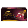 Slice of layered dessert on a plate with a box of Ulker Cikolatali Yas Pasta in the background. Ulker Milk Chocolate Cake with Velvety Red Velvet Base and Forest Berry Sauce – 13.9 oz (395 G)