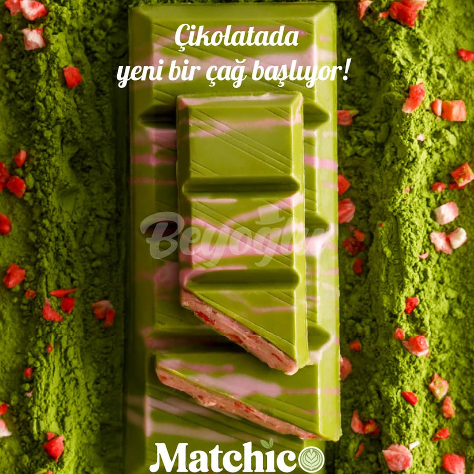 Green matcha chocolate bar with red strawberry pieces on a green background with matcha powder, featuring Beyoglu Matchico branding.