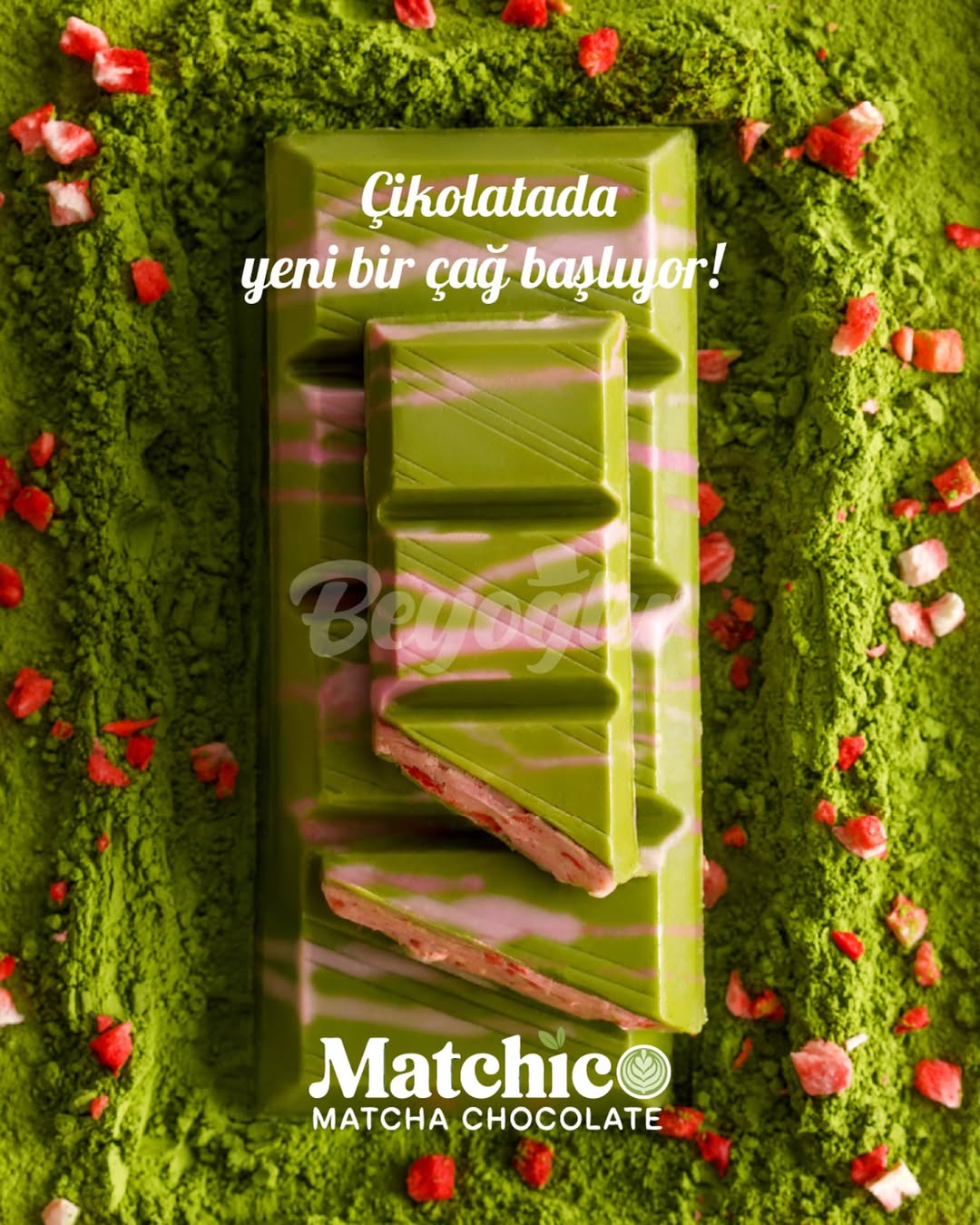 Green matcha chocolate bar with red strawberry pieces on a green background with matcha powder, featuring Beyoglu Matchico branding.