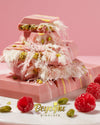 Close-up view of Beyoglu Angel Hair Raspberry White Chocolate showing raspberry strands, pistachio cream filling, and cotton candy texture